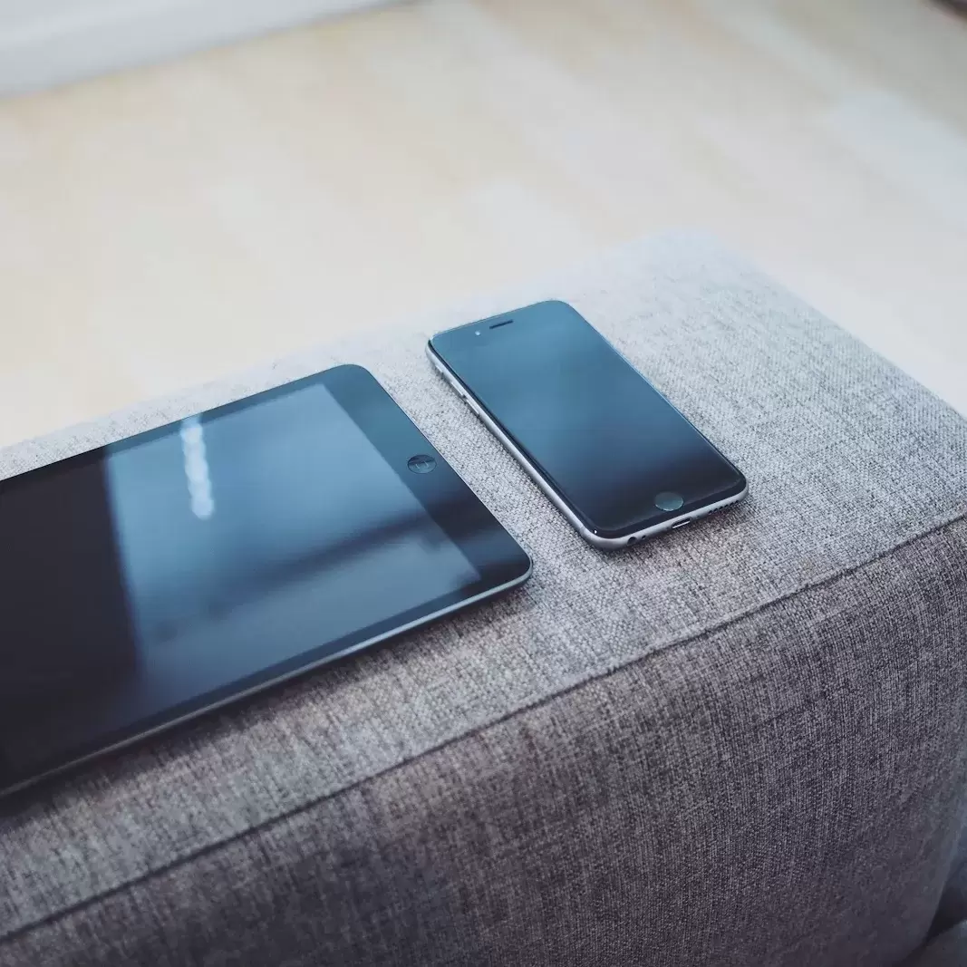a tablet and a smartphone on a couch